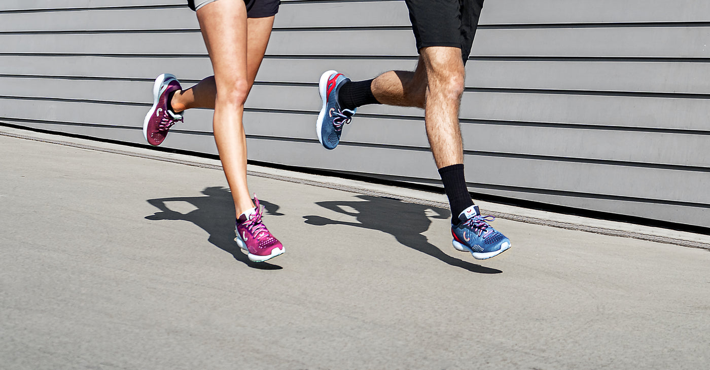 man and woman running in true motion running shoes