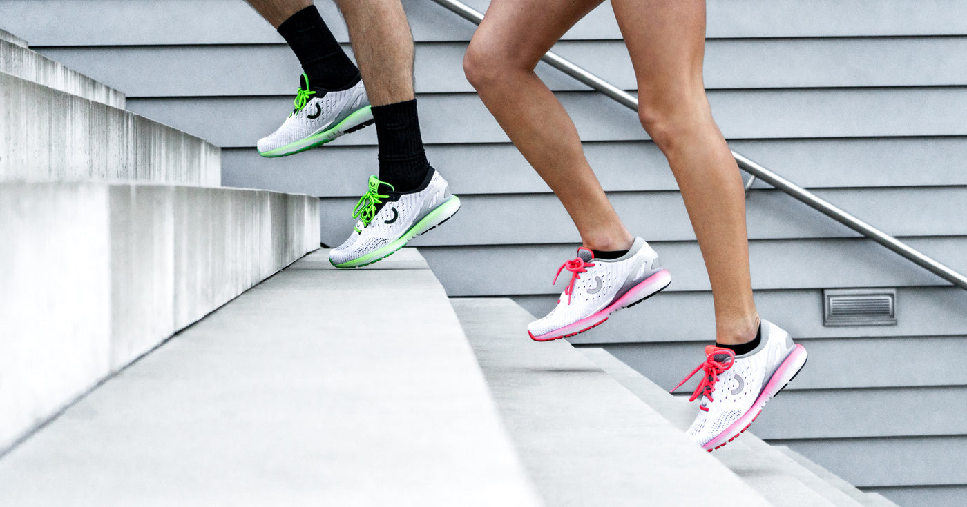 woman and man running up stairs in true motion running shoes