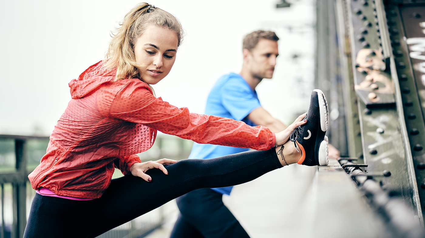 man and woman stretching in true motion shoes